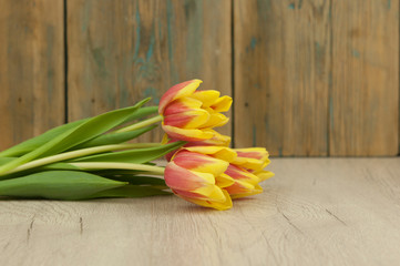 Yellow tulips over wooden table background with copy space