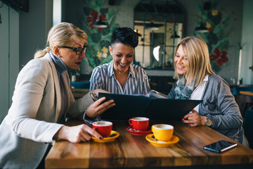 women friends looking at the menu in restaurant