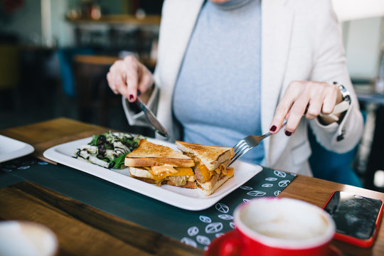 Close Up Of Woman Eating Toast In Restaurant