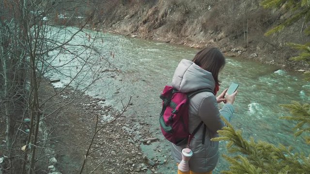 Female traveler taking photos with her smartphone. Girl travel blogger filming nature. Women backpacker walking outdoor. Self isolating at the nature. 