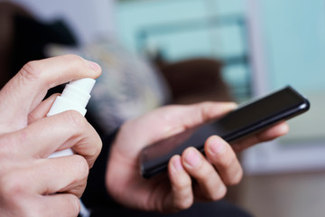 man disinfecting his smartphone.