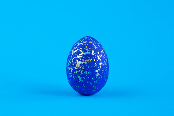 Christ is risen. Easter egg painted blue with gold and silver spray of paint.