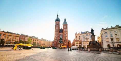 Fototapeta na wymiar Krakow's Main Square (Rynek Glowny) with St. Mary's Basilica church and Adam Mickiewicz Monument located at center of the Old Town district in Lesser, Poland