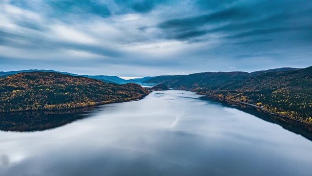 Aerial view of the Verrasundet fjord in Tr&oslash;ndelag county, Norway. The mixed forest covering the shores, the fjord is wide and deep. Dark blue clouds rushing above, reflecting in the calm waters.