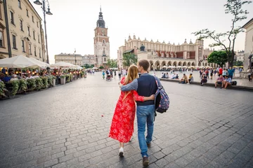 a young couple is stylishly dressed, a girl in a red dress, a man in a blue shirt and blue pants, walk the streets in Krakow Poland © Alexander