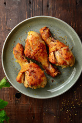Fried chicken legs in a gray plate. Grilled chicken legs. Crispy crust. Top view. Wood background. Vertical view.
