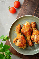 Fried chicken legs in a gray plate. Grilled chicken legs. Crispy crust. Top view. Wood background. Vertical view.