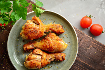 Fried chicken legs in a gray plate. Grilled chicken legs. Crispy crust. Top view. Wood background. Horizontal view.