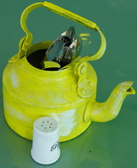 Kitchen utensils and cutlery in old fashioned green vintage teapot in bucket on table along with...