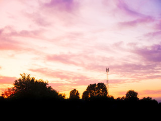 view over a beautiful sunset behind a radio antenna tower.