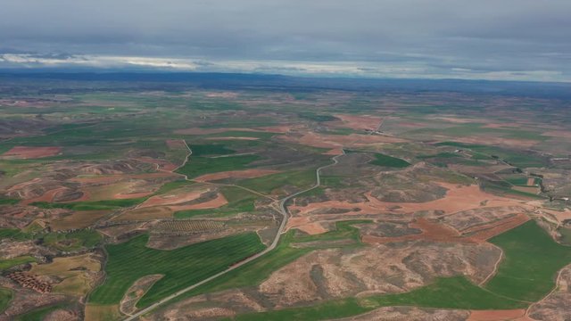 aerial view desert landscape with a road and green fields high altitude Spain Teruel province 