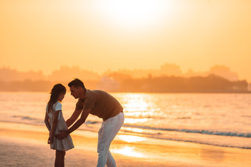 Beautiful father and daughter at the beach enjoying summer vacation.