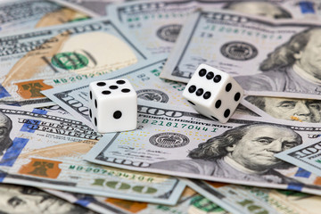 Closeup to two white dice on 100 dollar bills. Concept of gambiling, stock market risk and return