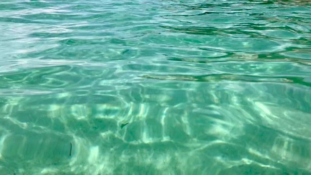Incoming rippling clear cyan sunlight water ripples with white sand  Mediterranean sea floor