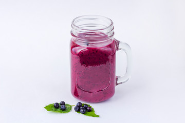 Blueberry smoothie in mason jar mug with mint and some fresh berries on white  background. The concept of proper nutrition and healthy eating. Organic and vegetarian drink. Close up, copy space for