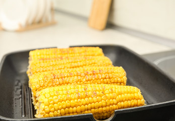 Fresh corn cobs on grill pan, closeup