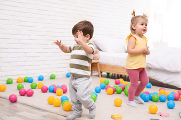 Cute little children playing together at home