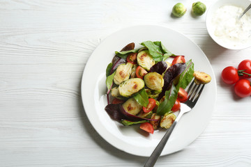Delicious salad with roasted Brussels sprouts on white wooden table, flat lay