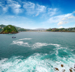 Obraz premium Ocean wave crashing on rock in the bay