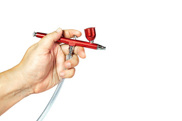 Red airbrush spray tool in hand for paintingg hobby or work for art .