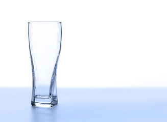 Empty glass on a soft blue background.