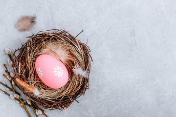 Colorful Easter egg in the nest on gray stone concrete background