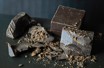 Broken chocolate on black background.