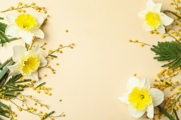 Flat lay composition with spring flowers on beige background, space for text