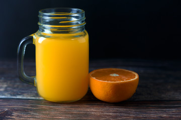 Orange juice in a jar and citrus fruits on the table Summer drink