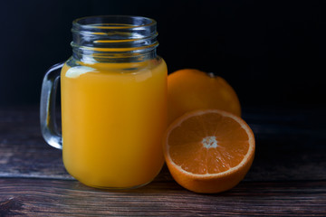 Orange juice in a jar and citrus fruits on the table Summer drink
