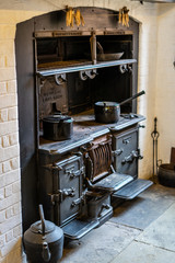 an old wood burning stove in a kitchen with pots and pans on top