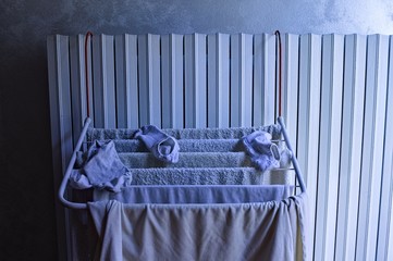Little clotheshorse hanging on the radiator with towels, socks and a t-shirt (Pesaro, Italy, Europe)