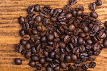 Freshly roasted coffee beans. Background of roasted coffee beans scattered on a wooden table.