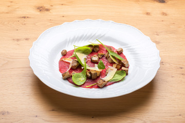 Carpaccio di manzo con funghi porcini, grana padano e rucola