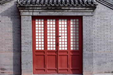 Red Chinese traditional style wooden door on brick wall