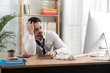 Lazy employee sleeping at table in office