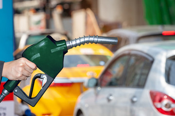 Fuel nozzle separated from road traffic background. white Clipping Path
