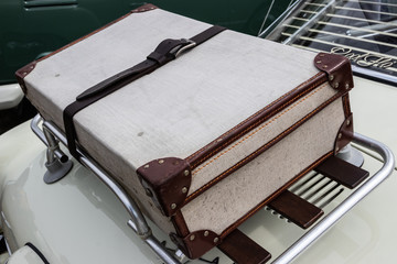 An old suitcase on a car roof rack