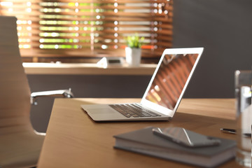 Laptop on wooden table in modern office