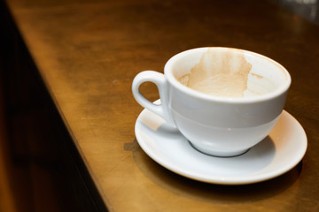 empty cup after coffee, slkdy coffee on a white cup, dirty cup on the bar