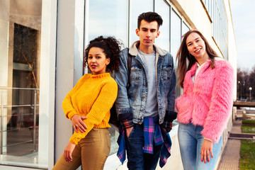 cute group of teenages at the building of university with books huggings, diversity nations real students lifestyle