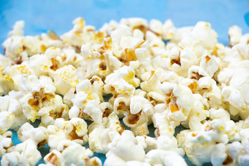 Salty butter popcorn laying on the blue grunge background