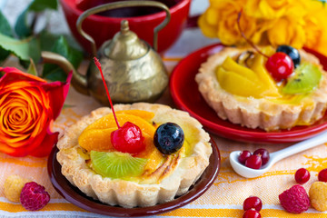 fruit and berry cream tartlets close up, bright healthy desserts