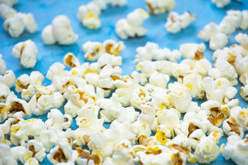 Salty butter popcorn laying on the blue grunge background