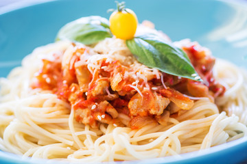 Delicious  spaghetti pasta dish served on a blue plate