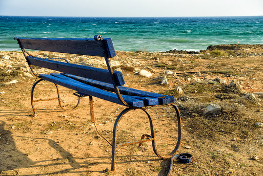 Blue wooden bench by the sea
