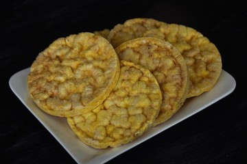 corn round waffles on a white plate on a black background