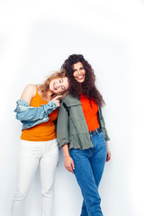 young pretty teenage girls friends with blond and brunette curly hairs posing cheerful isolated on white background, lifestyle people concept