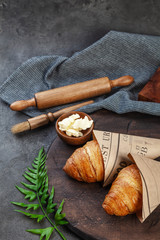 Fototapeta na wymiar Fresh crispy baked croissants and butter on wooden board