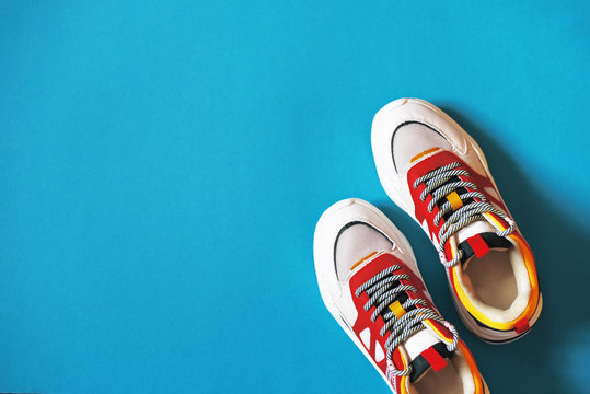 Unisex multi-colored sneakers on a blue background.